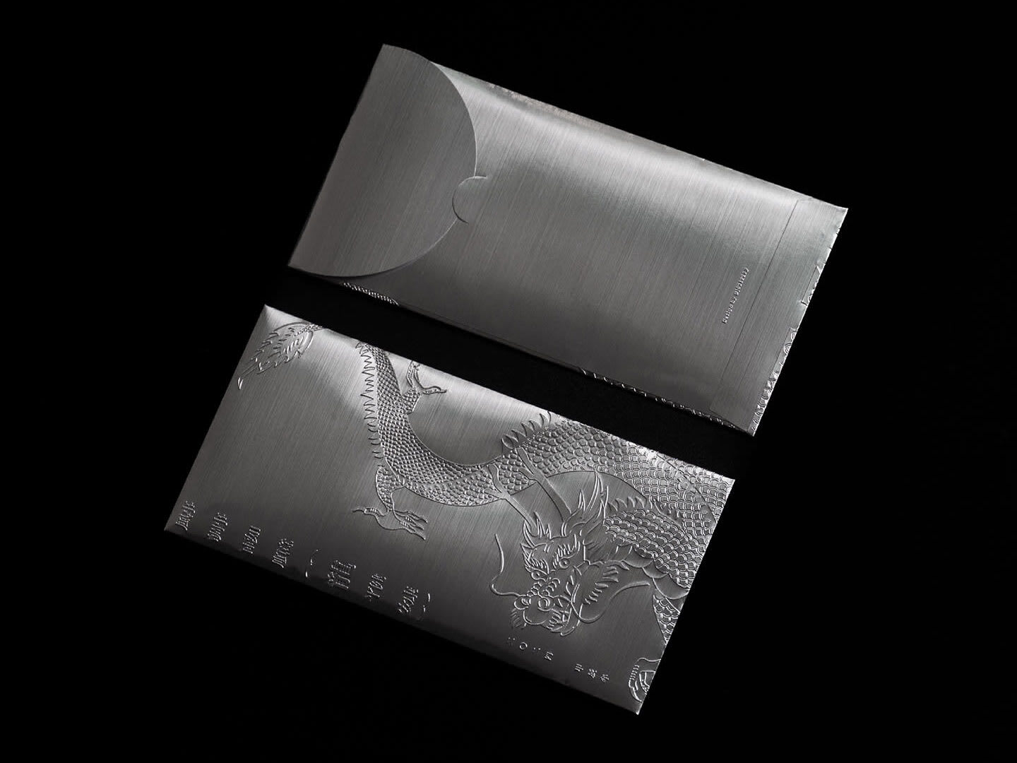 Chrome envelope packaging design with dragon embossing, an example of the Pure Steel packaging trend 2026