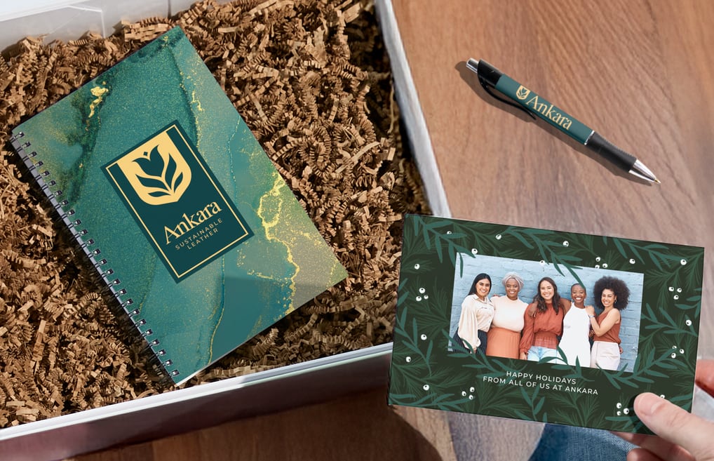 Team photo printed on a holiday card mailed to customers with a branded notebook and pen.