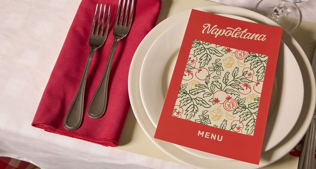 Bi-fold menu placed on plates at a restaurant