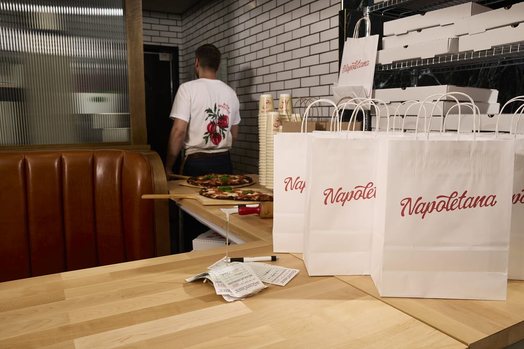 White paper bags with a red logo for a restaurant’s packaging design