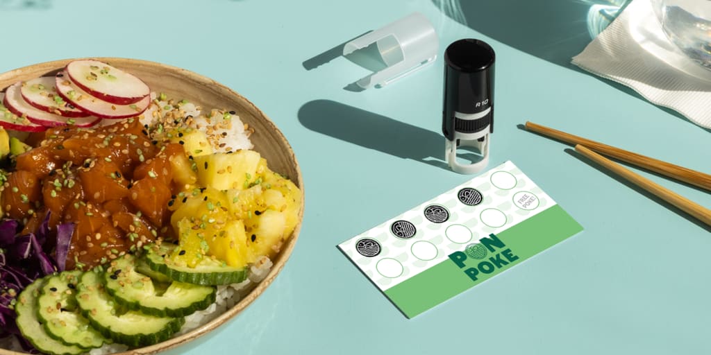Custom stamp on a loyalty card beside a fresh poke bowl on a mint green background