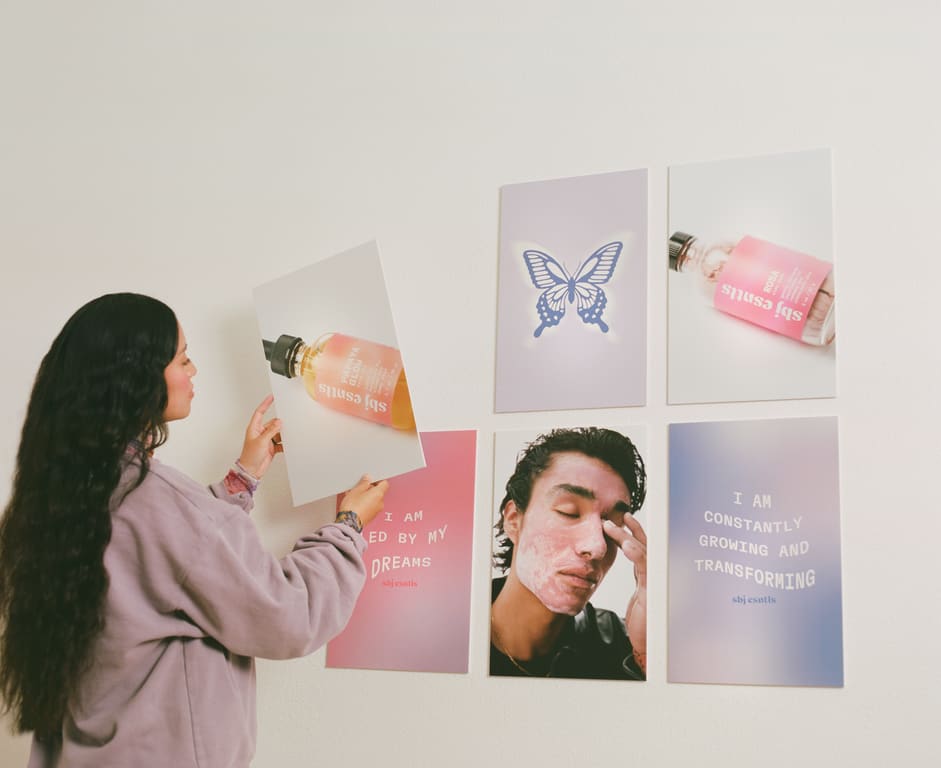 Woman hanging pastel sbj esntls skincare brand signage.