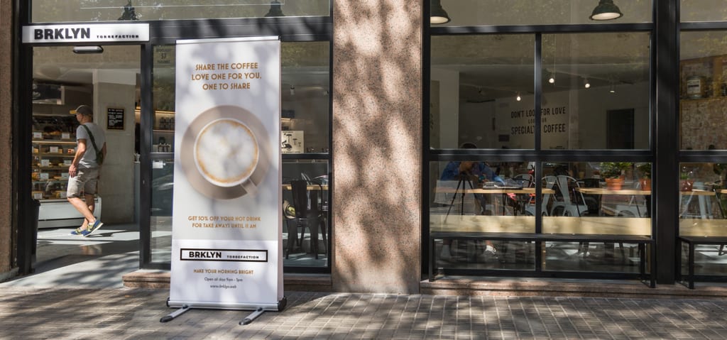 Coffee shop retractable banner on the street offering a discount