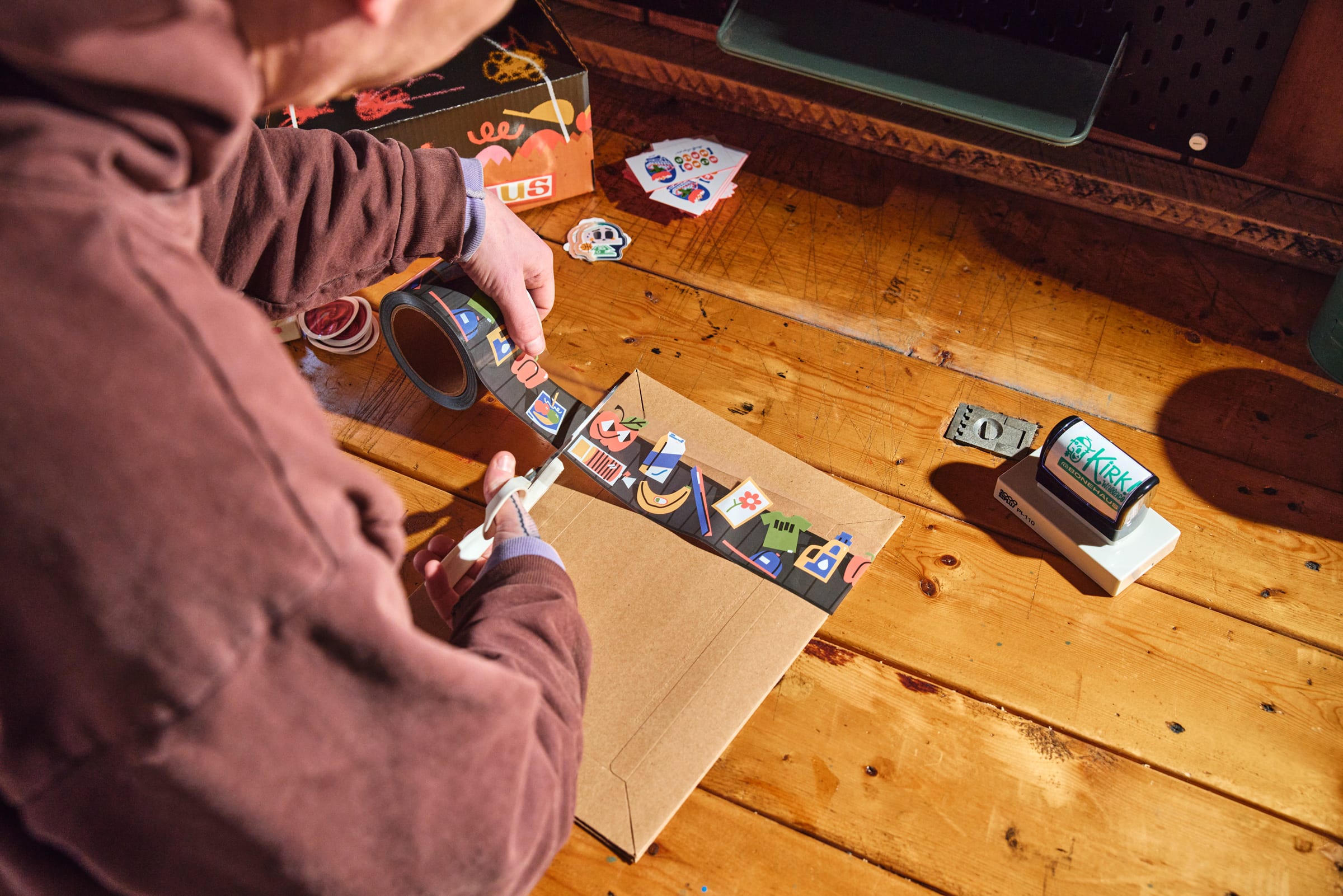 Kirk Wallace cutting branded packaging tape with custom stickers