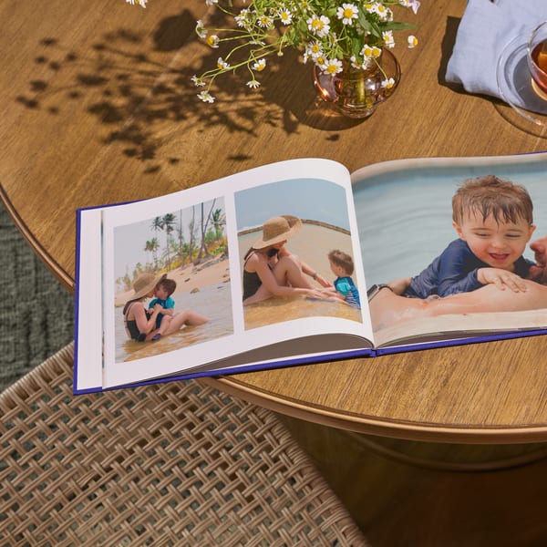A personalized photo book with family photos laying flat open on a table