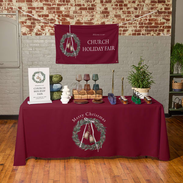 Custom holiday tablecloth and hanging banner at a church holiday fair