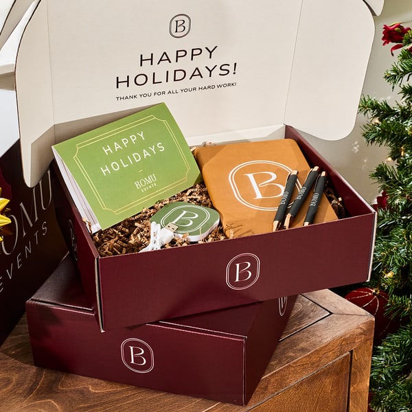 A branded box with a custom card and company swag to give away to employees at an office holiday party