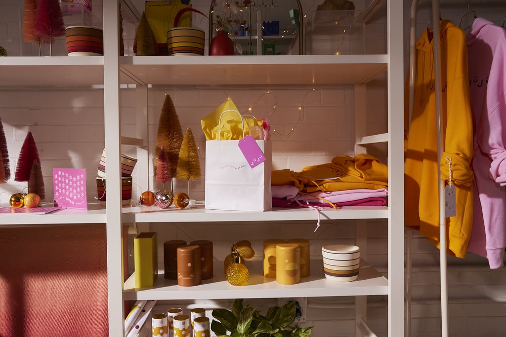 A gift bag with paper wrapping on a shelf surrounded by homeware products