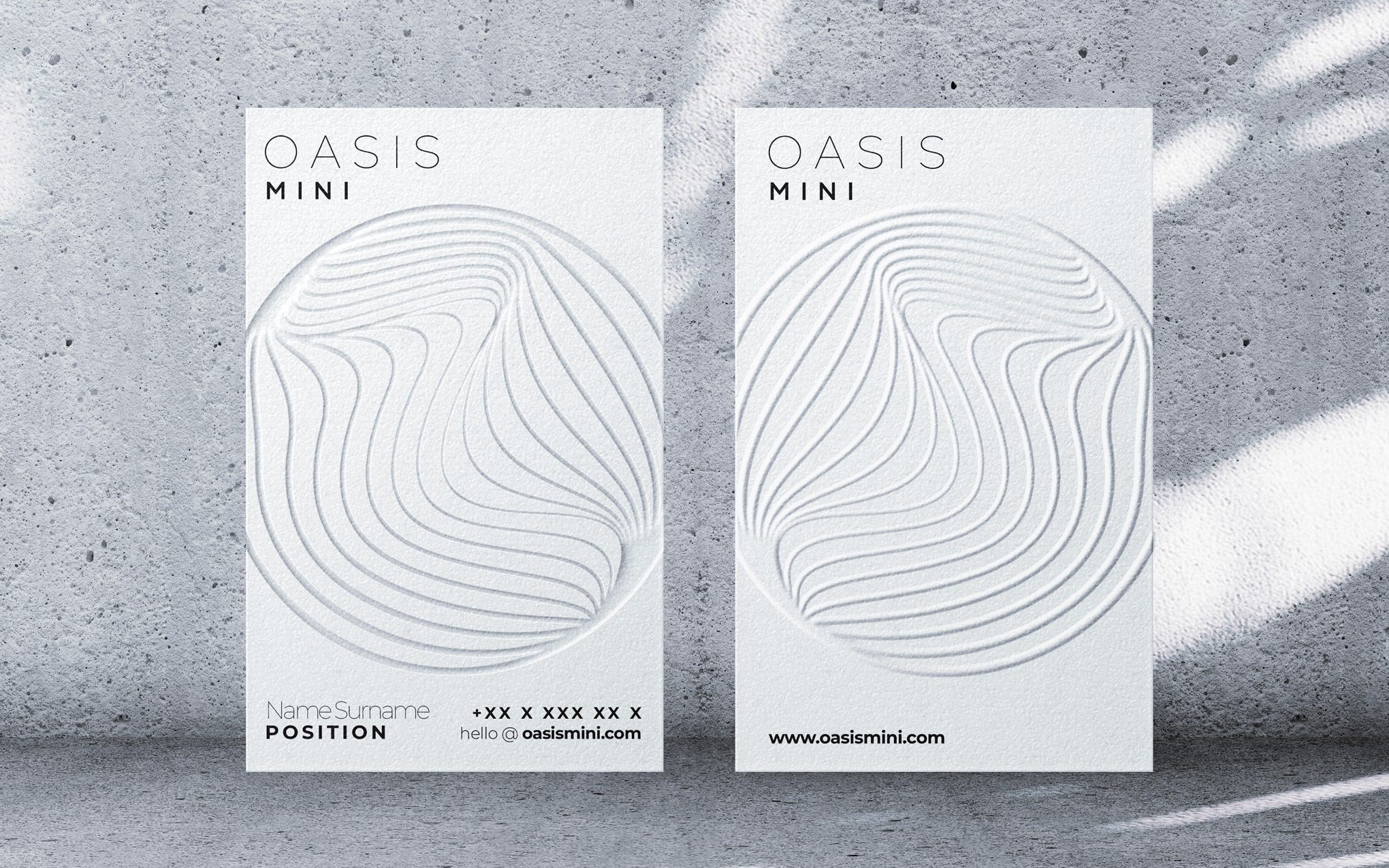all-white business card with an embossed circular design and black text