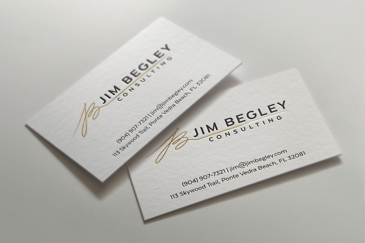 white business card with black text and a gold logo