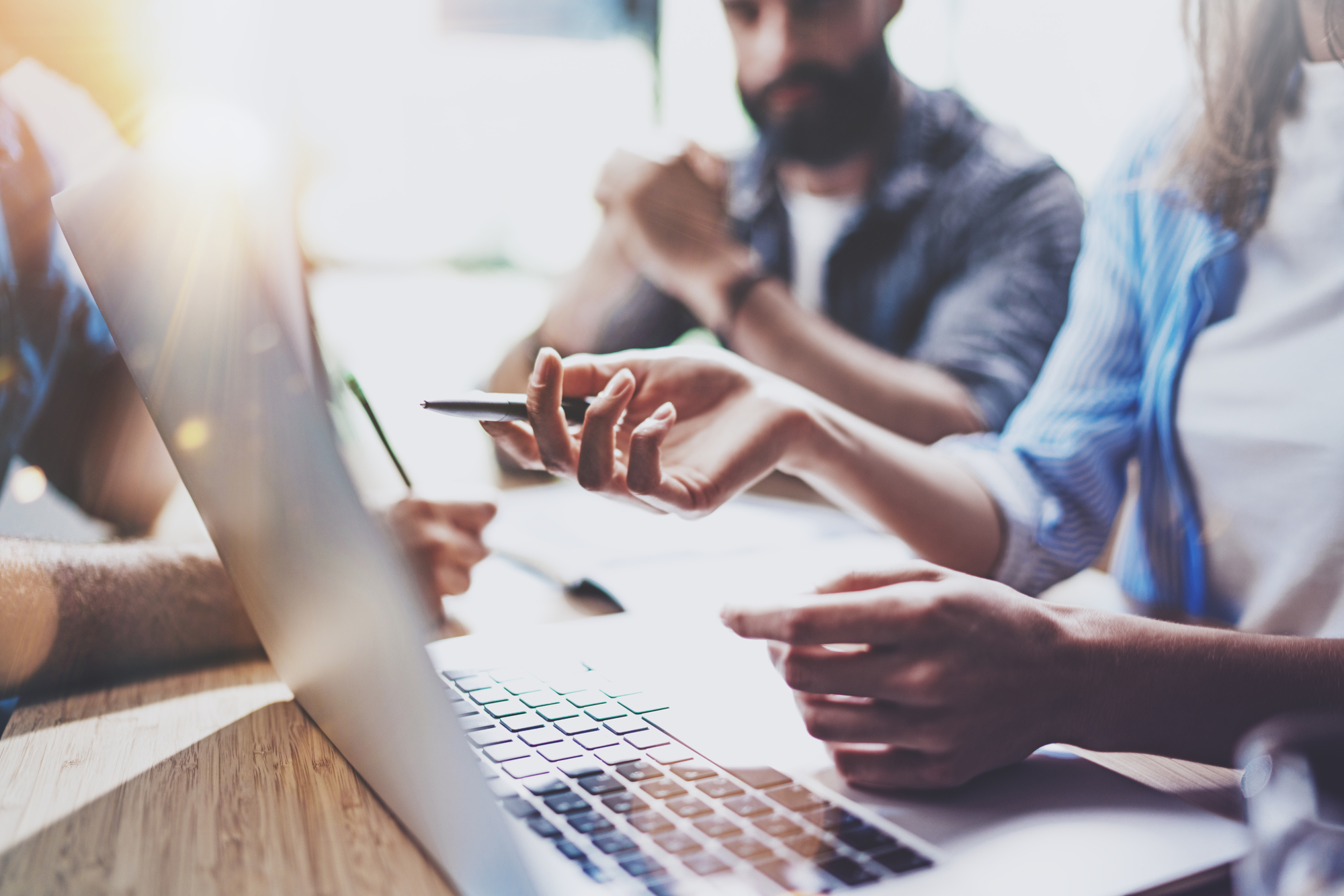 People looking at a computer thinking of goals for their marketing plan