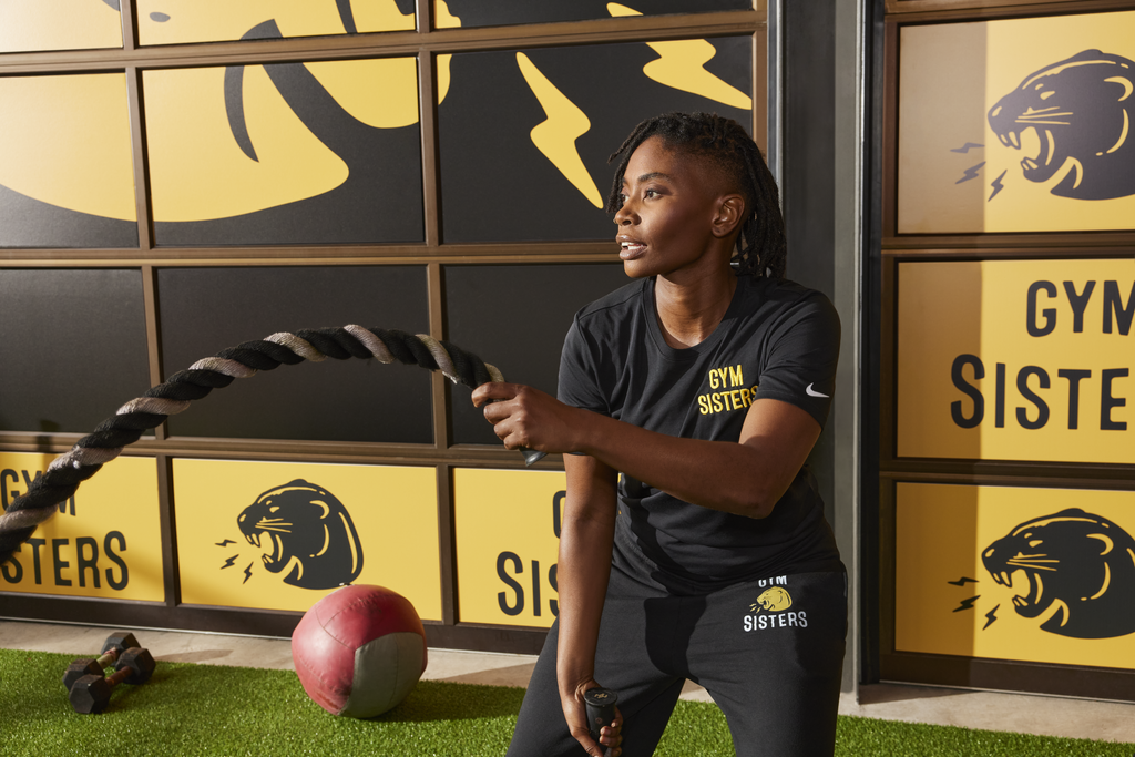 Gym goer with promotional shirt does functional workout.