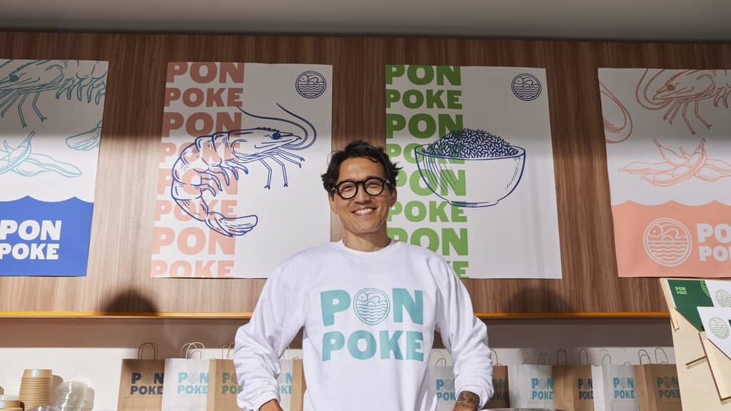Poke shop business owner standing in front of branded posters, DPI for printing