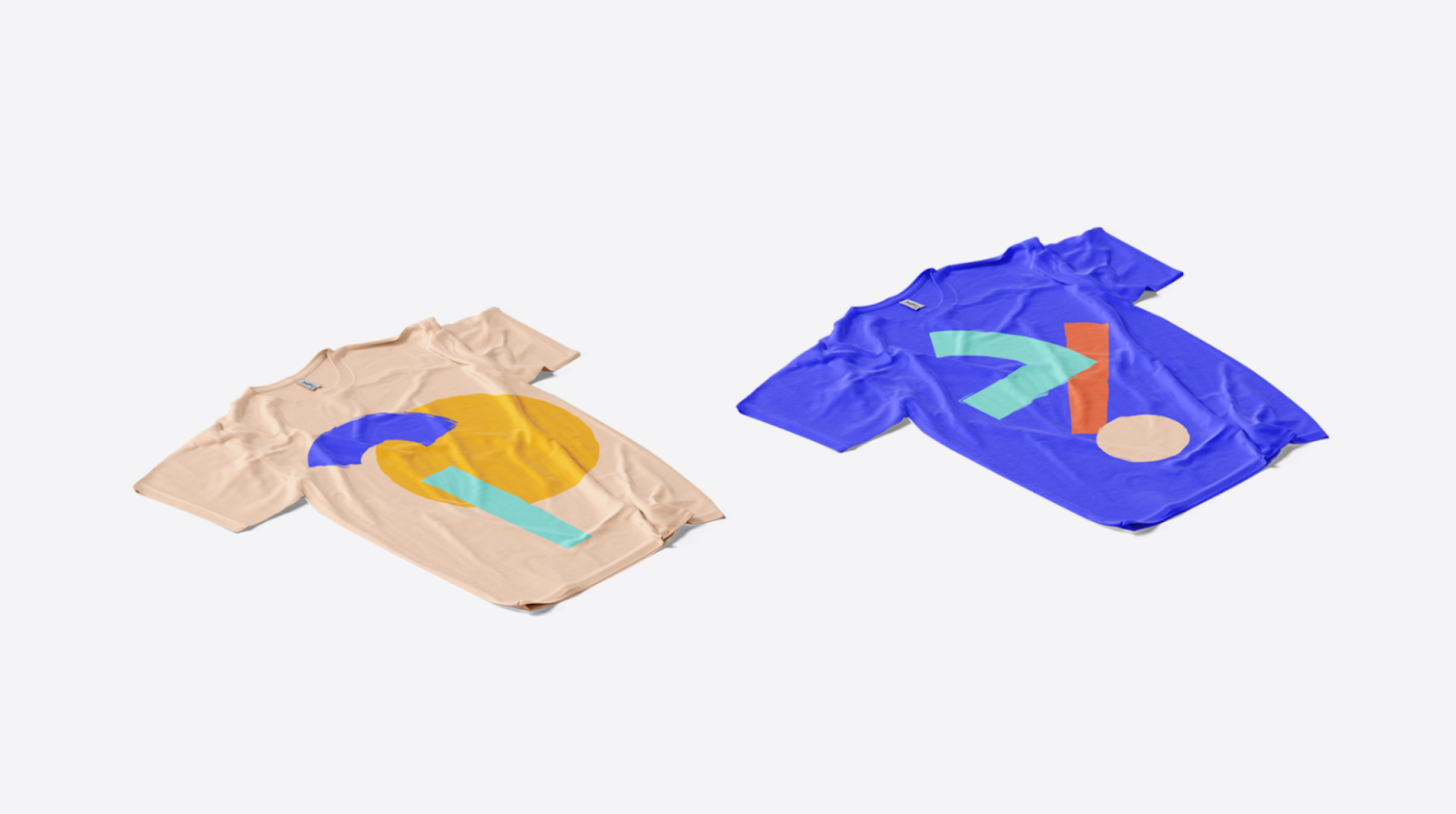 Two T-shirts with abstract geometric designs in bold colors, shown on neutral and blue fabric