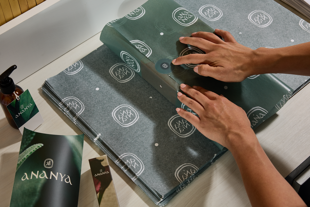 Small business owner wrapping custom tissue over a product