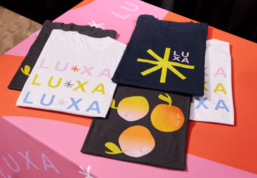 A table featuring a range of black and white T-shirts with multi-colored branded prints