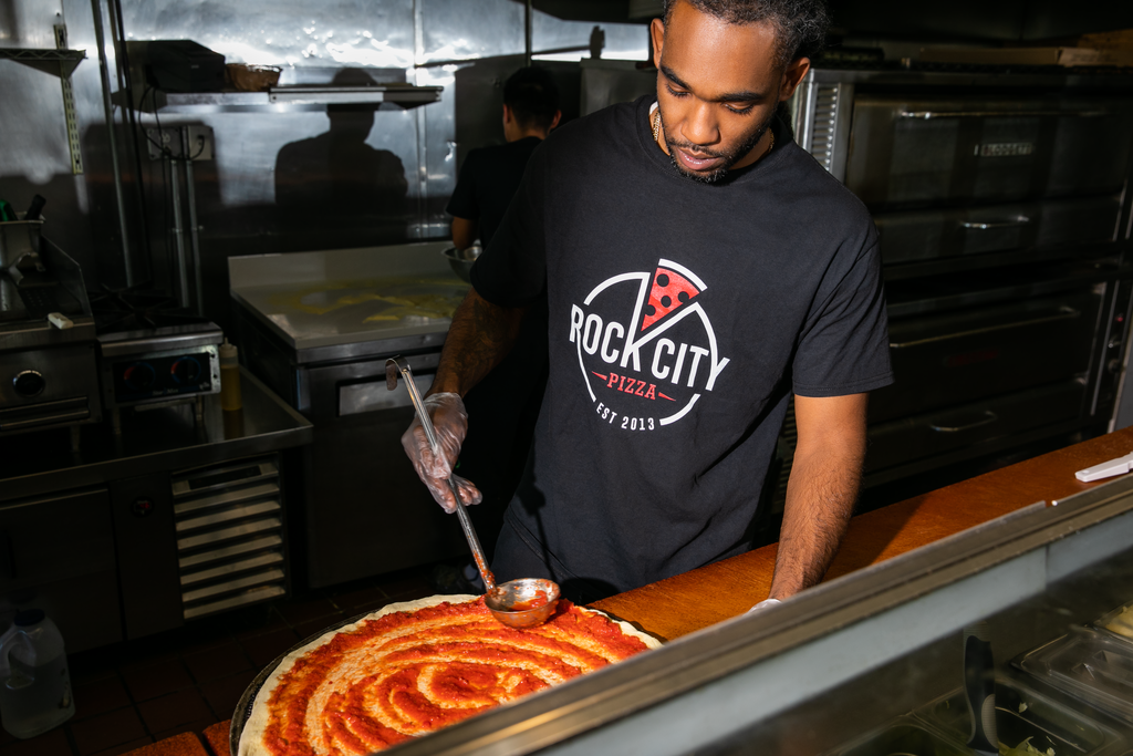 Pizza employee wearing a branded logo T-shirt