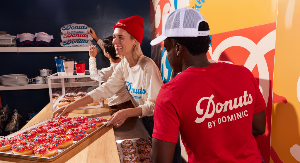 Donut shop employees wearing branded apparel with different logo placements front and back
