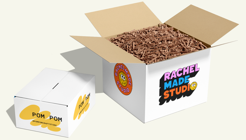 Large and smaller custom white cardboard package with chunky multicolored “Rachel Made Studio” text on front panel and orange circular logo on side panel