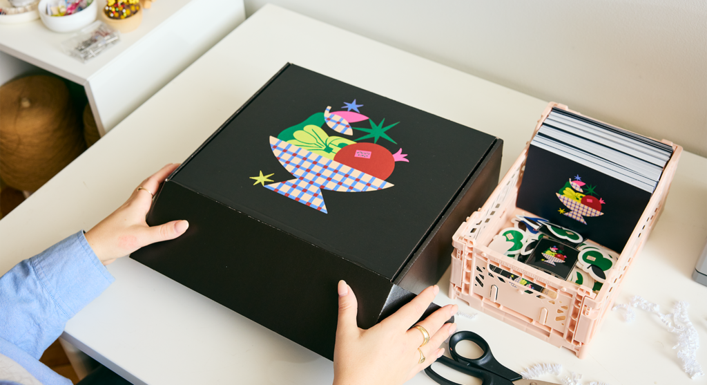 A black cardboard box with an illustration of a bowl of fruit on the front