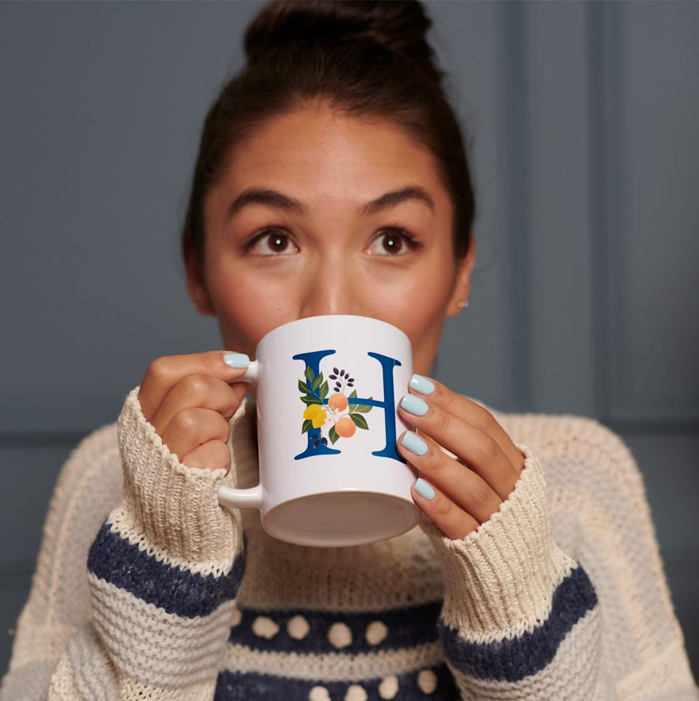 A woman drinking from a personalized mug