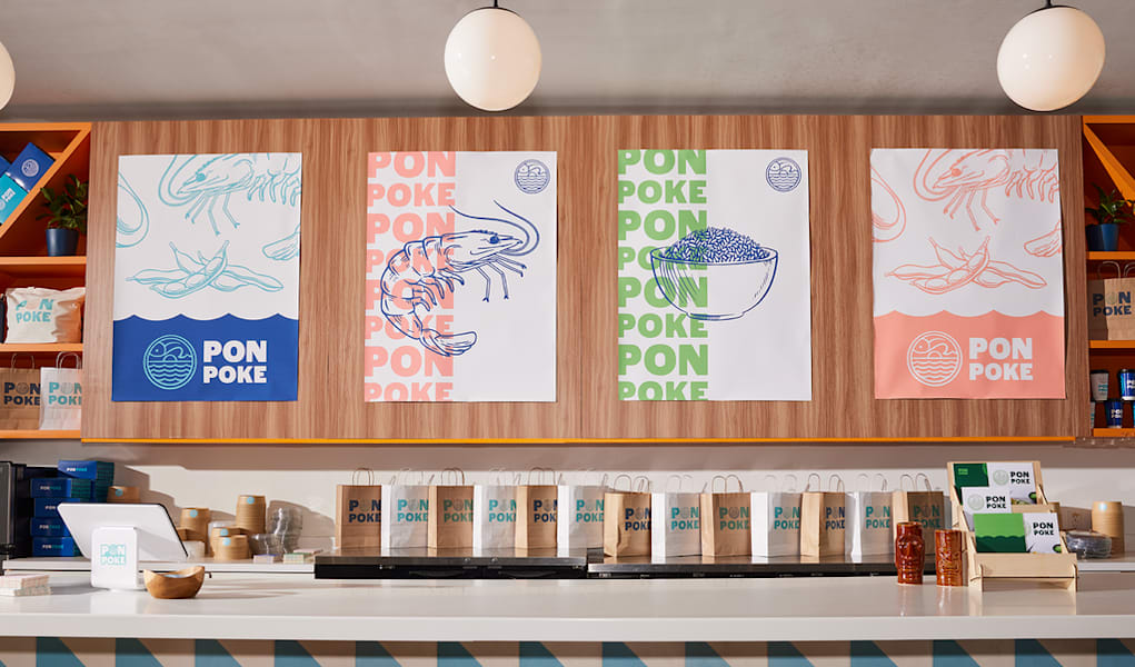 Colorful store counter with branded poster fonts, coordinated menus, paper bags, and logo stickers.