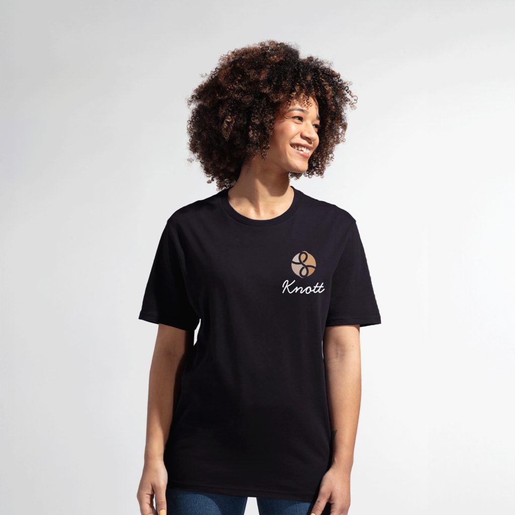 A woman in a black Allmade T-shirt with a custom logo