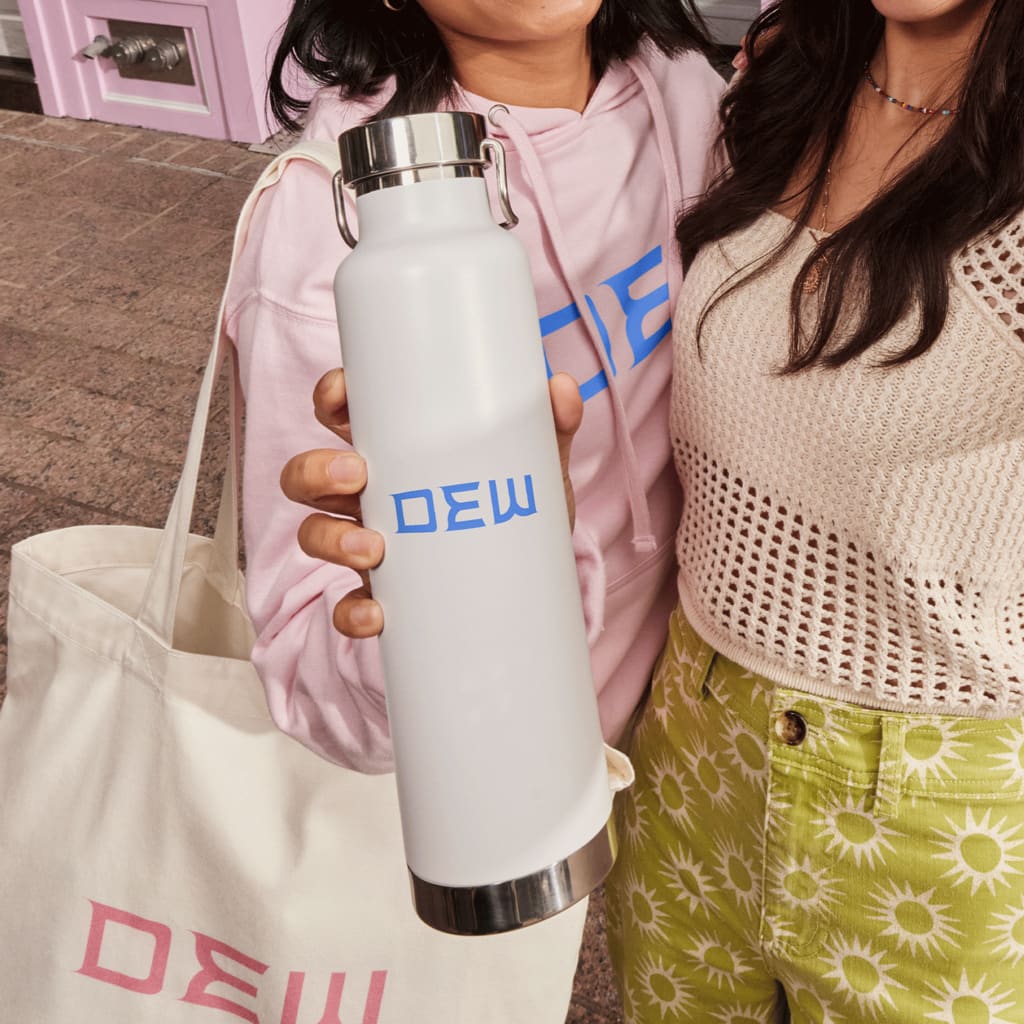 Young woman holds up a white metal branded water bottle with minimalist design.