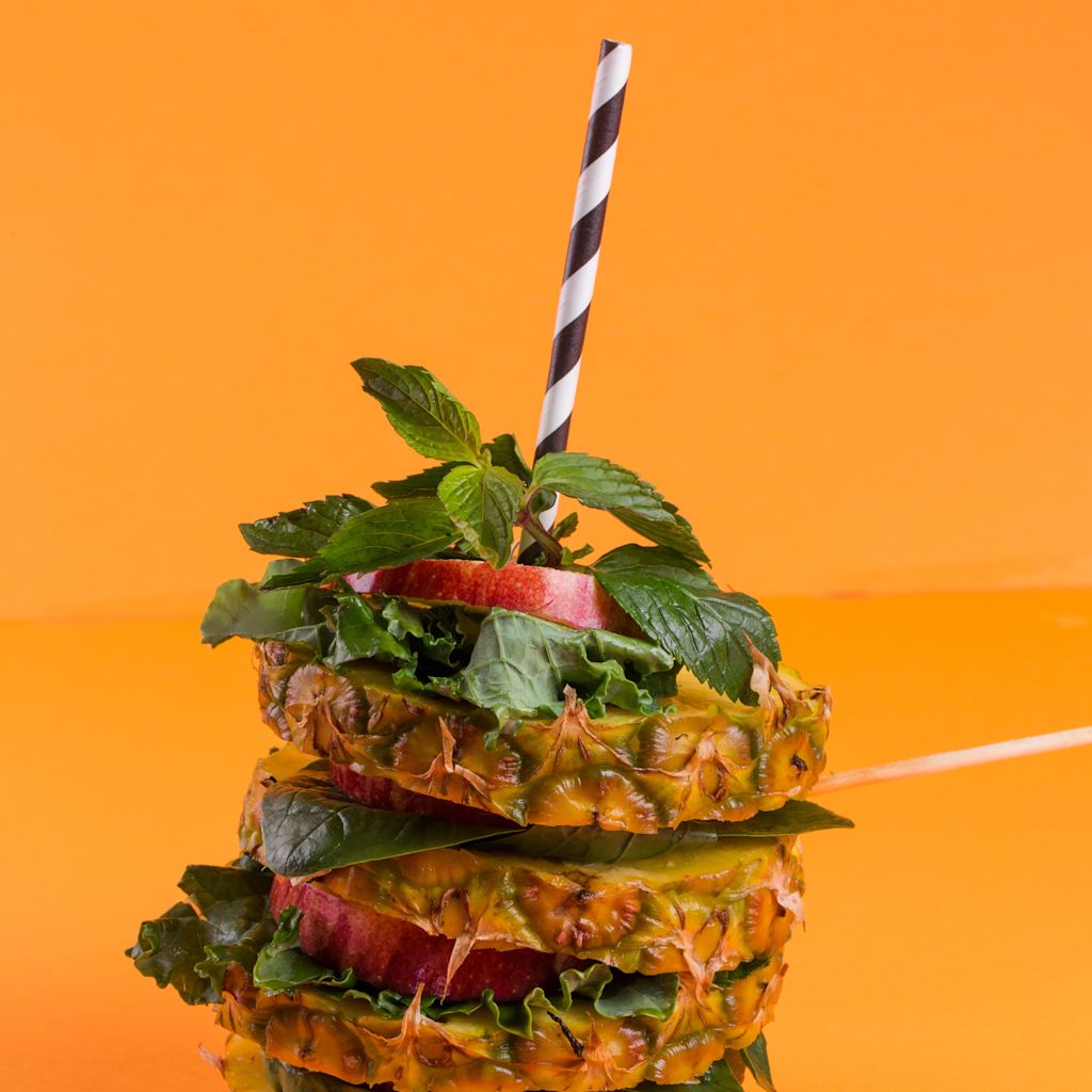 Pineapple and apple slices with a straw through them