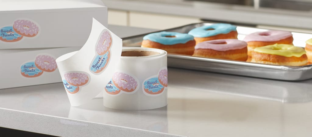 Donuts in a bakery with matching promotional stickers.