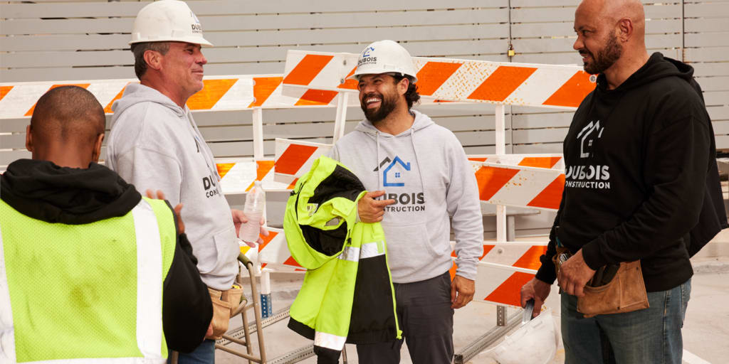 A team of construction workers in branded hoodies