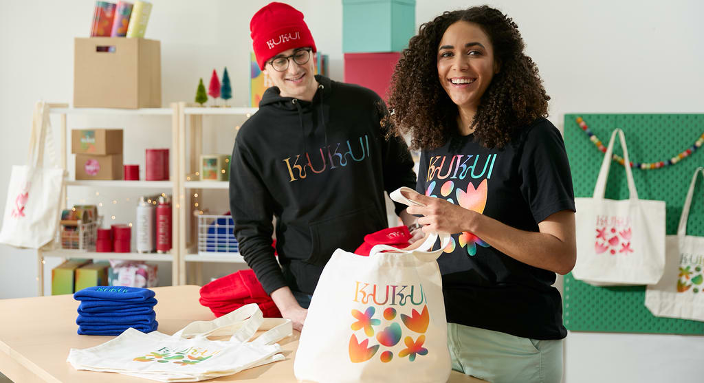 A branded tote bag with flower design in rainbow gradient
