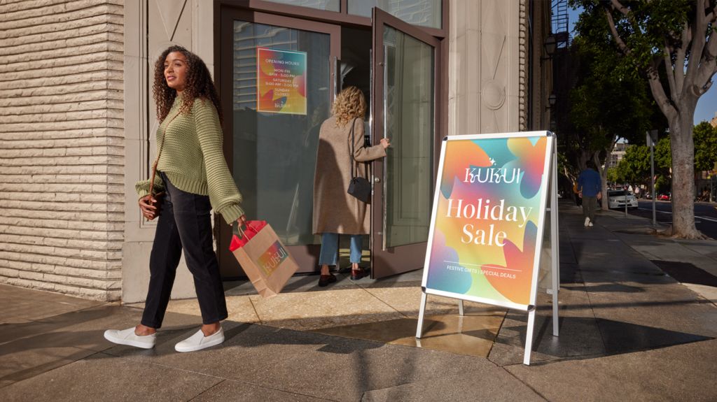 customers outside a store with a holiday sale sign