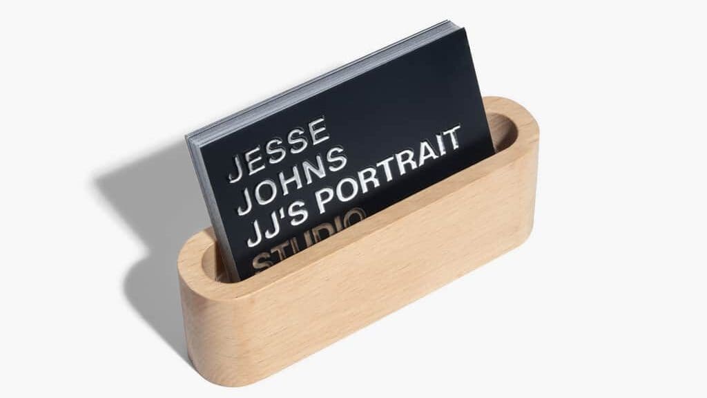 A stack of typographic business cards in a business card holder