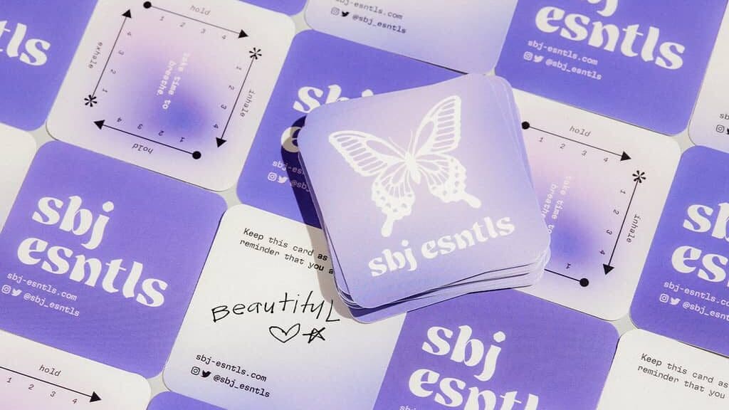 A stack of square business cards with the brand’s logo and name