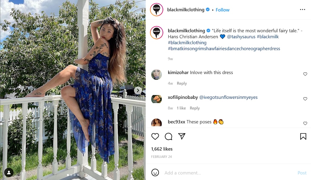 A woman sits on a ledge while she flaunts her blue dress