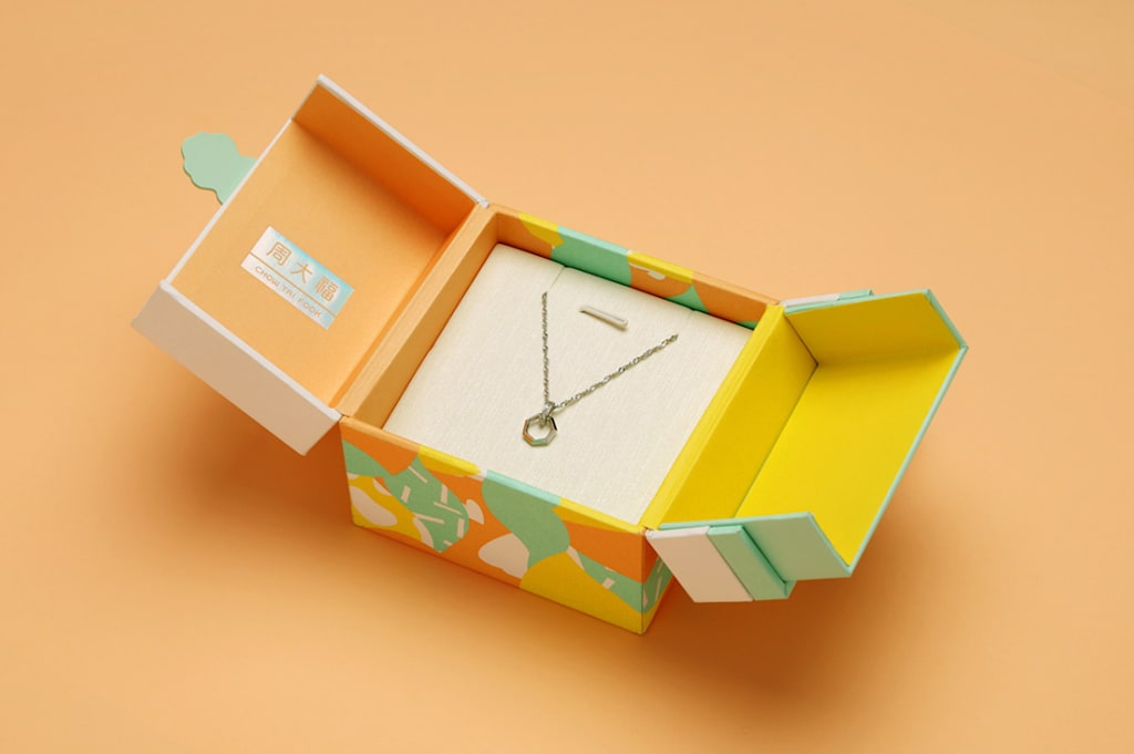 open yellow, white and green box, showing a gold necklace