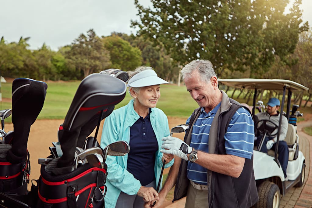 Out for a day of good green fun. a senior couple choosing their clubs while enjoying a day on the golf course