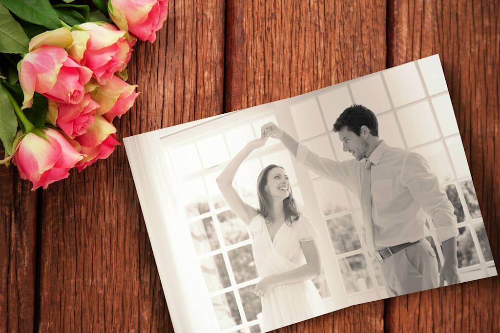 A photo of a dancing wedding couple alongside some roses