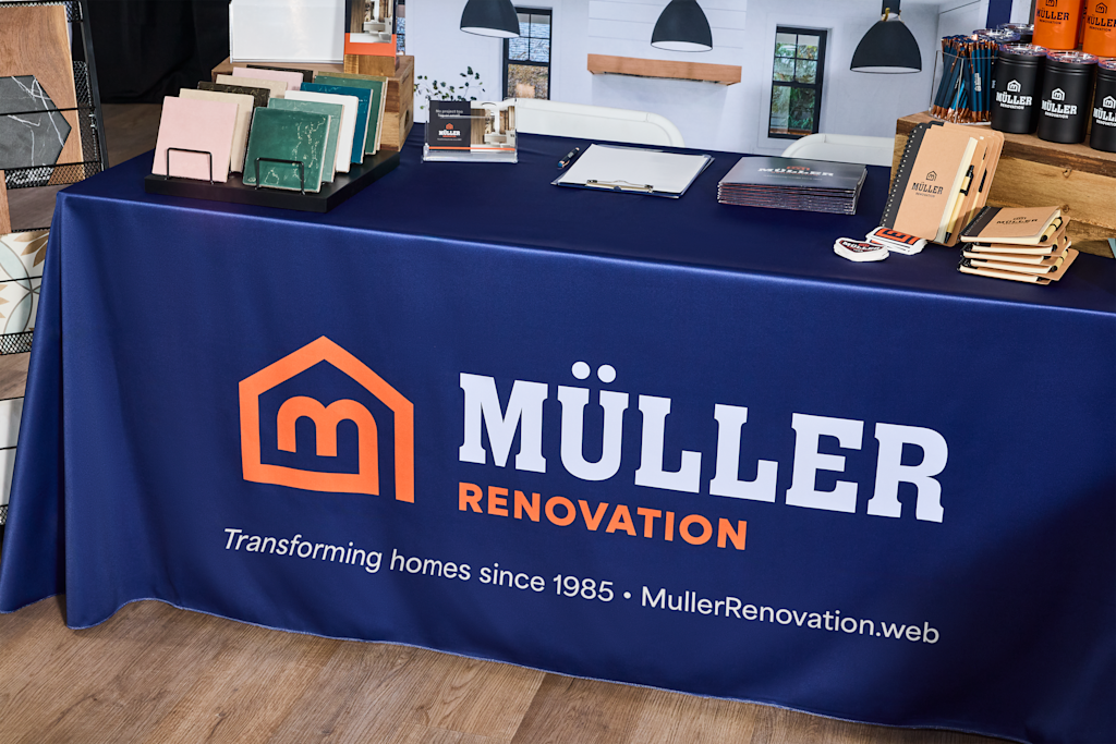 Branded tablecloth and product samples displayed at a home renovation trade show booth.