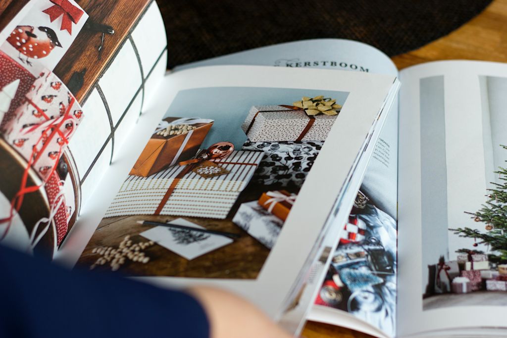 Open catalogs with images of presents and a Christmas tree