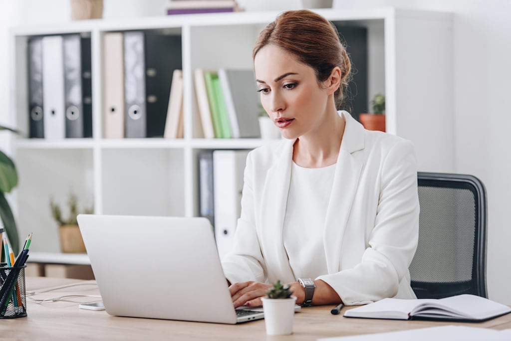 A woman works on a document on her laptop.