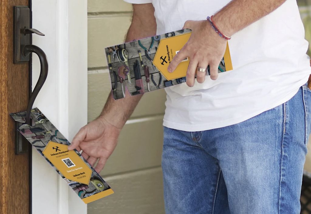 Close-up of man hanging door hanger on door handle