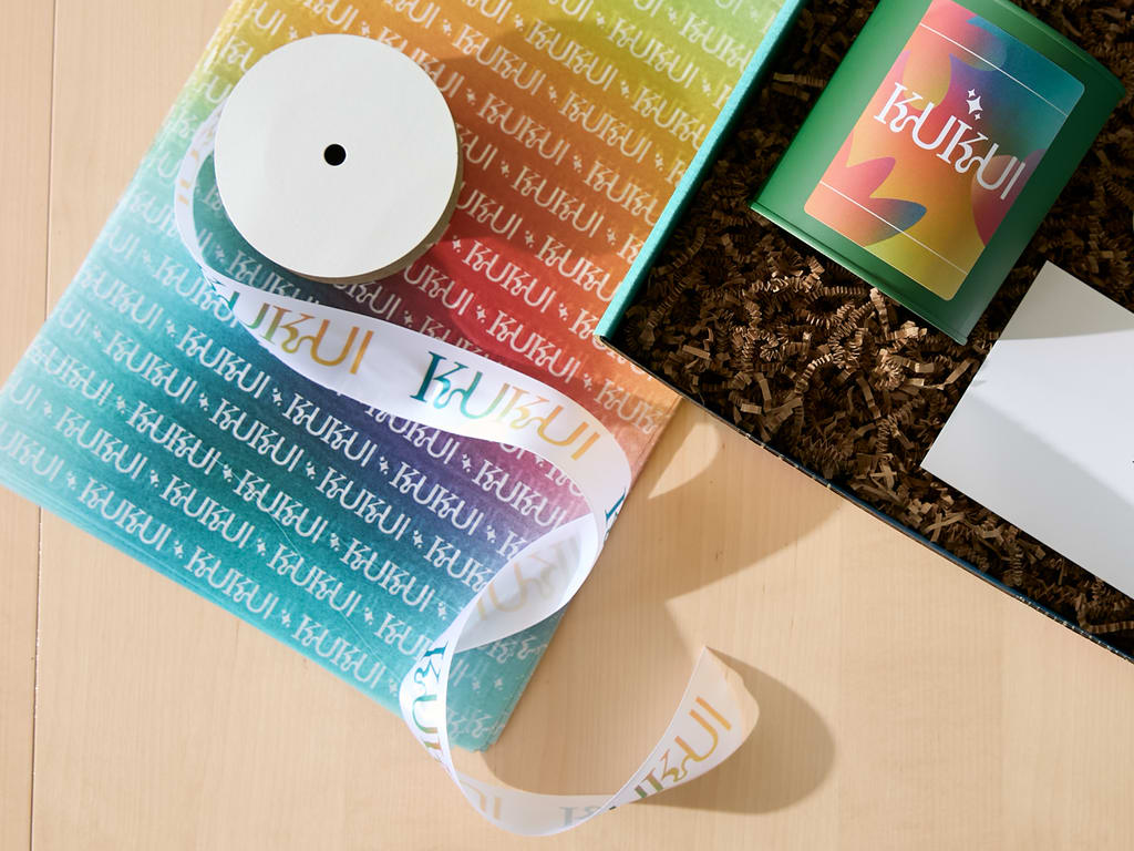 Brand packaging with branded tissue paper, ribbons and textured inserts.