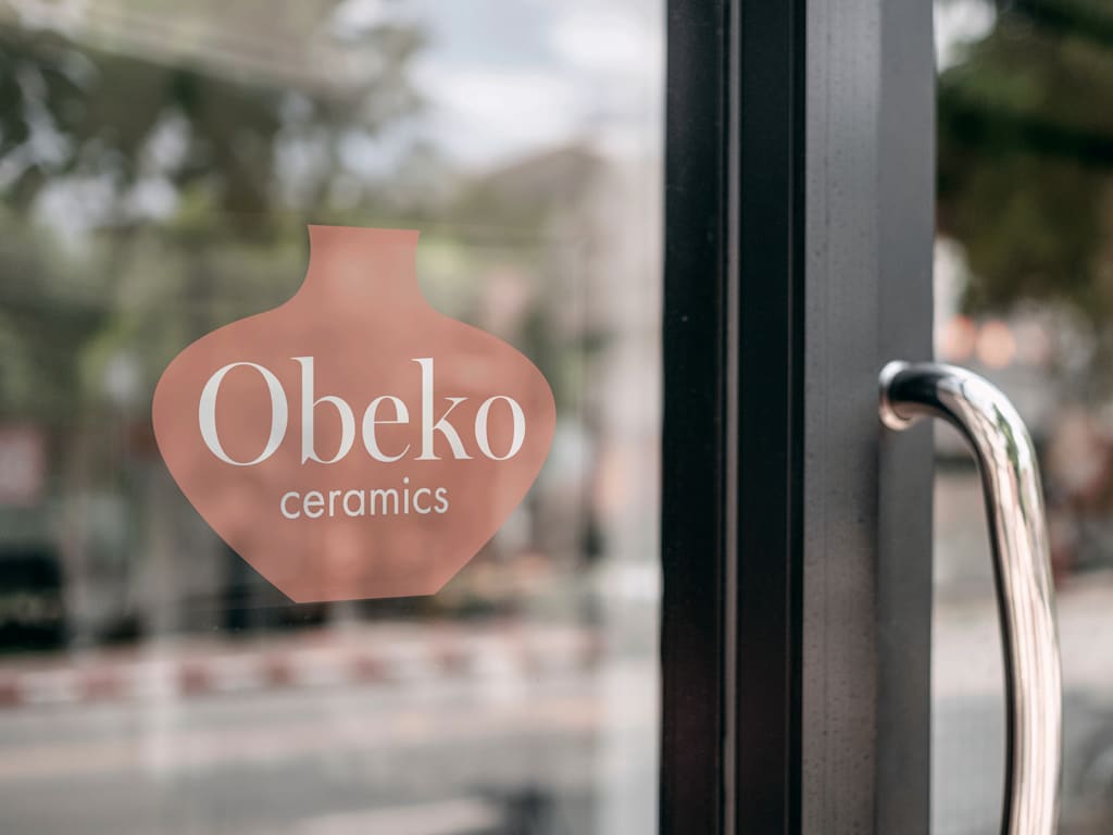 A branded window decal retail store signage example for a ceramics shop