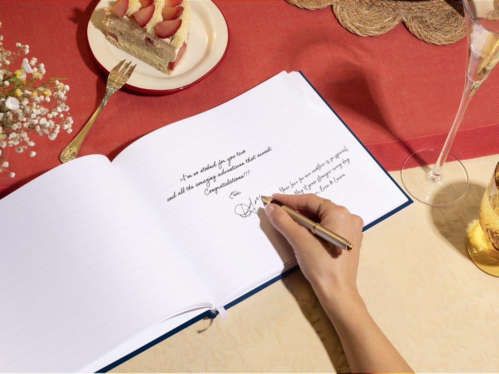 Une personne écrit dans un livre d’or minimaliste à un mariage