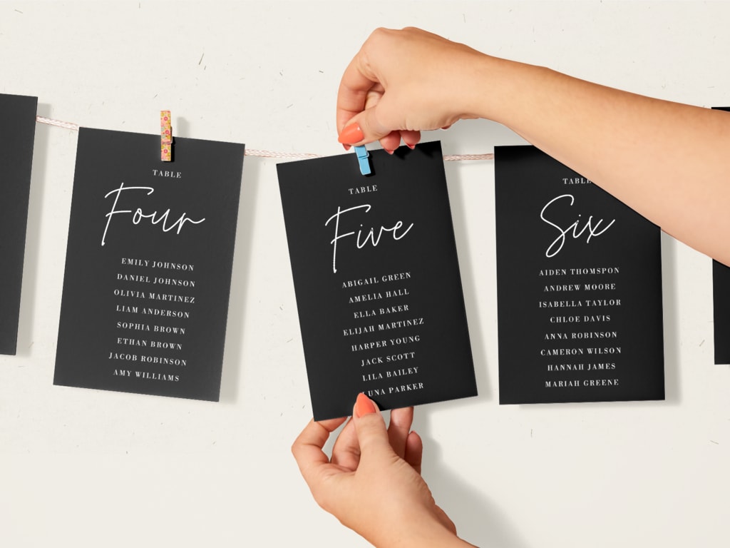 Wedding seating charts hung on a clothesline