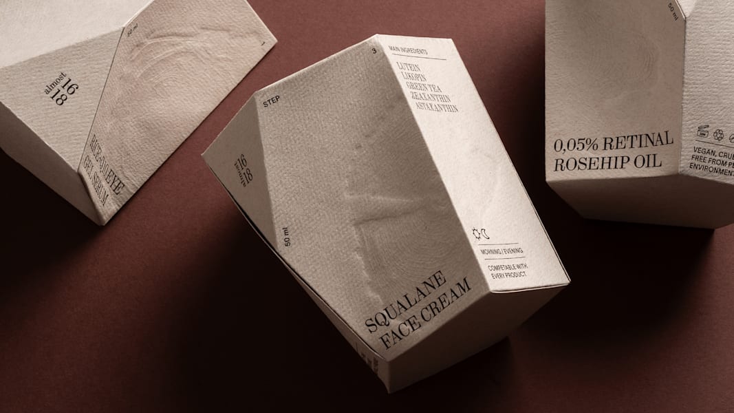 Emballage de crème pour le visage de forme irrégulière, volontairement compact et imparfait, comportant des éléments de pressage — un exemple de la tendance d’emballage Empreintes de 2026.