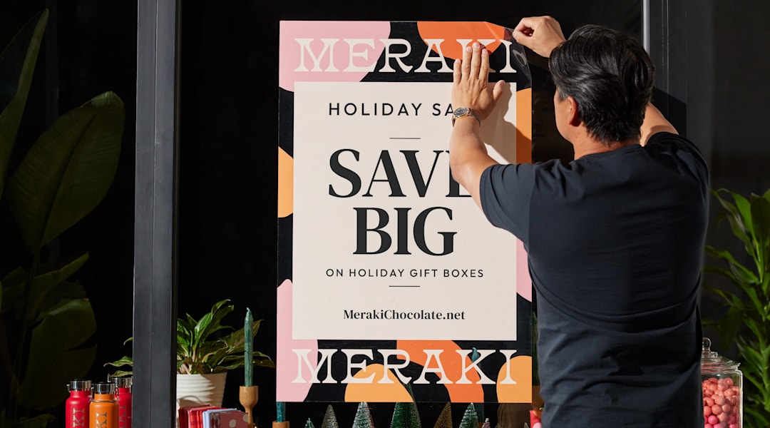 person puts up poster in store