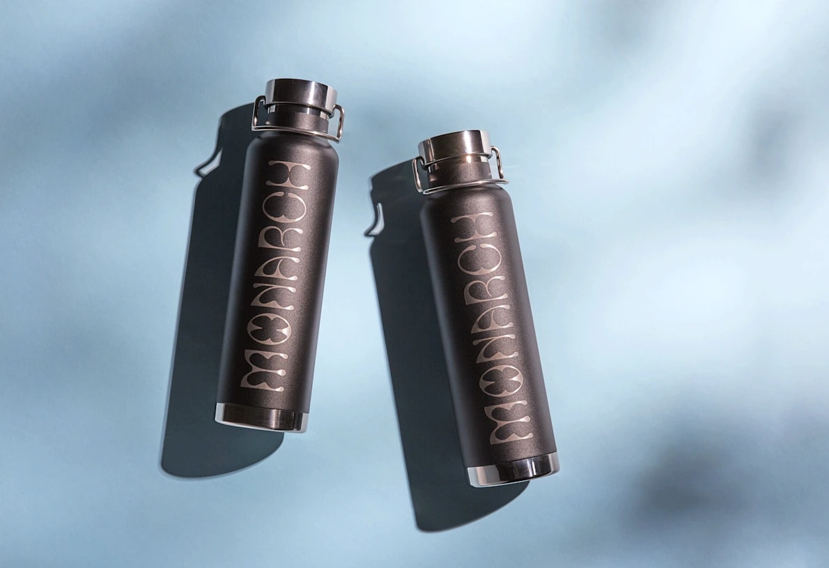 Two dark gray water bottles featuring a logo that says &ldquo;Monarch&rdquo;